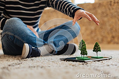 Boy having tree miniatures on his tablet Stock Photo