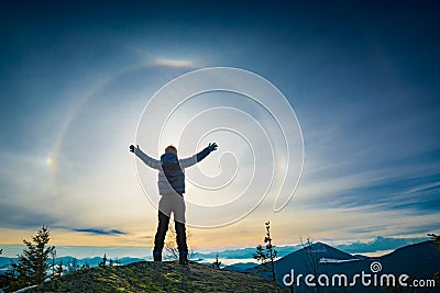 The boy hiker standing with raised hands on a top of mountain Stock Photo