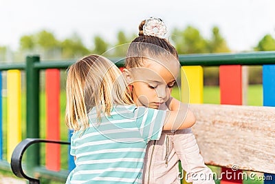 boy on his back cuddles and apologizes to his sister Stock Photo