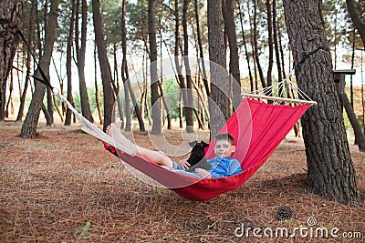 Boy and his dog relaxing in hammock Stock Photo