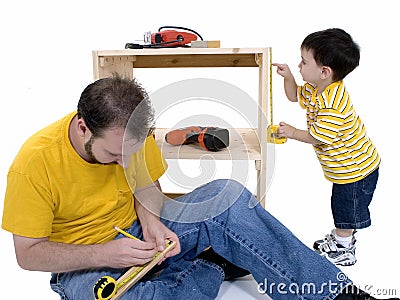 Boy And His Father Building A Storage Cabinet Together Stock Photo
