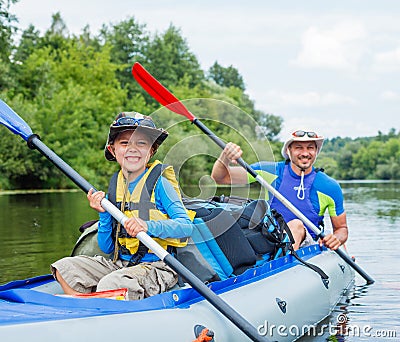 Boy with his father kayaking Stock Photo