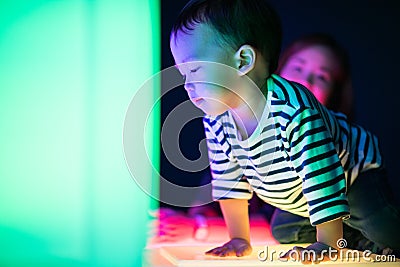 A boy and his mom are playing colorful light cubes. Stock Photo