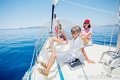 Boy with his sister and mother on board of sailing yacht on summer cruise. Stock Photo