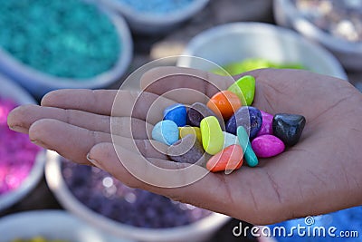 Boy holding beautiful colorful stones in hand Stock Photo