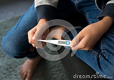 A boy Holding a digital Thermometer Stock Photo