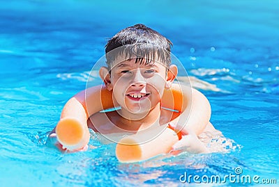 Boy holding on the pool noodle buoy for safety. Stock Photo