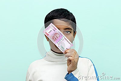 Boy holding 2000 rupee new Indian money in his hand. Stock Photo