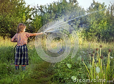 Boy hose garden on summer day Stock Photo