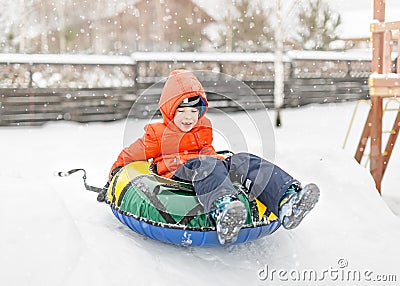 Boy with the inflatable sledge, snow tube Stock Photo