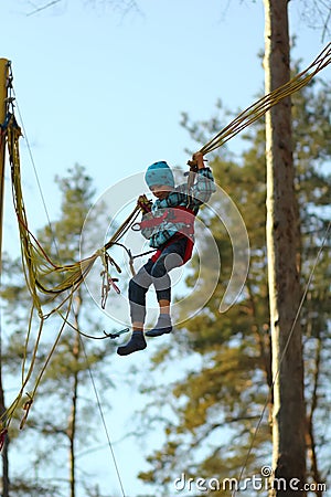 Boy jumping on a bungee trampoline and flying in the air in the autumn park Stock Photo
