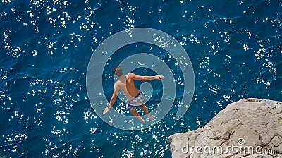 Boy jumping off rock into Aegean Sea Editorial Stock Photo