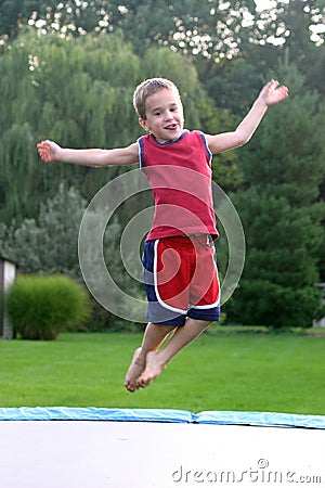 Boy Jumping on Trampoline Stock Photo