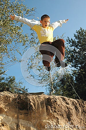 Boy jumps above the chasm Stock Photo