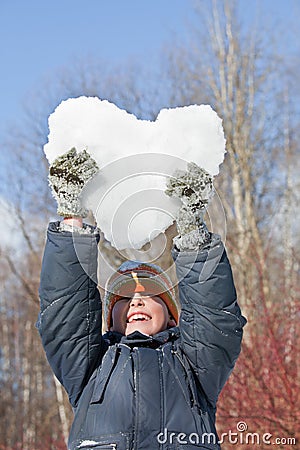 Boy keeps in hands hearts from snow over head Stock Photo