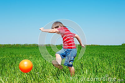 Boy kicking ball Stock Photo