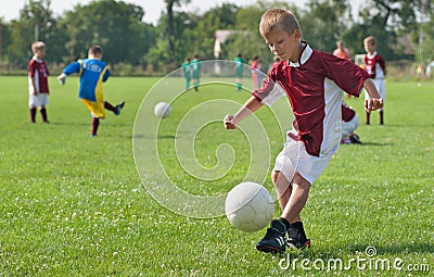 Boy kicking football Stock Photo