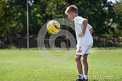 Boy kicking football Stock Photo