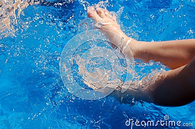 Boy kicking in pool Stock Photo