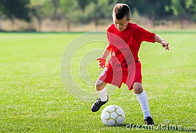 Boy kicking soccer ball Stock Photo