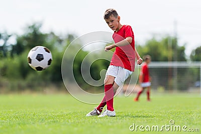 Boy kicking soccer ball Stock Photo