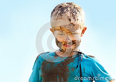 Boy, kid and mud on face with smile from playing, dirt or happiness in summer weather or water. Child, person and Stock Photo