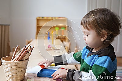 Boy in kindergarden with drawing crayons Stock Photo