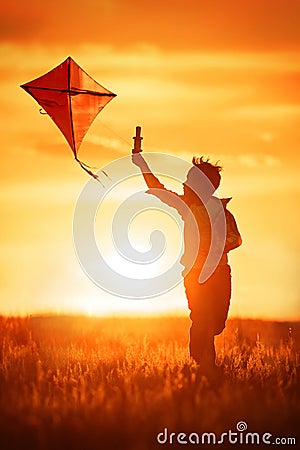 Boy with a kite at sunset Stock Photo