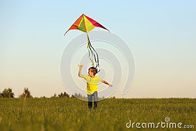 The boy launches a kite. Summer day. Sunny.The boy in a yellow t-shirt with a kite Stock Photo