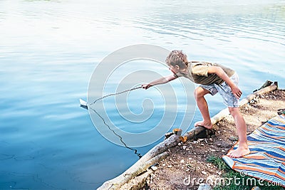 Boy launches the paper boat in lake Stock Photo