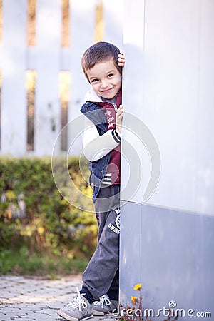 A boy leaning on a wall, smiling Stock Photo