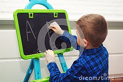 The boy is learning to read and write . The child learns the alphabet Stock Photo