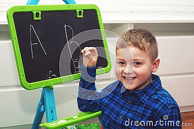 The boy is learning to read and write . The child learns the alphabet Stock Photo