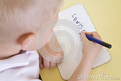 Boy learning to write name in primary class Stock Photo
