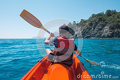 Boy in life jacket on orange kayak Stock Photo