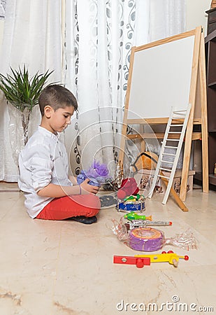 Boy lining up toys at home. Stock Photo