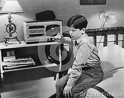 Boy listening to radio in bedroom Stock Photo