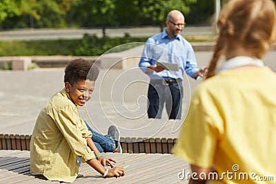 Boy Looking at Friends during Outdoor Lesson Stock Photo