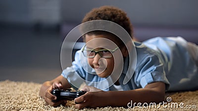 Boy looking at screen while playing video game, health harm, sedentary lifestyle Stock Photo