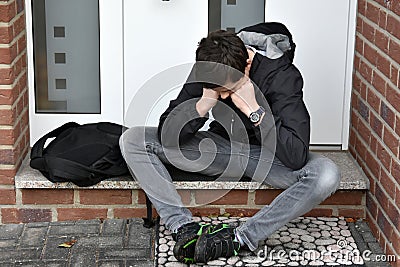 Boy is waiting for someone with front door key Stock Photo