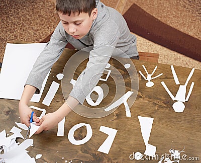 Boy makes origami - car and family, children, parent, I love you text, top view on wood background Stock Photo