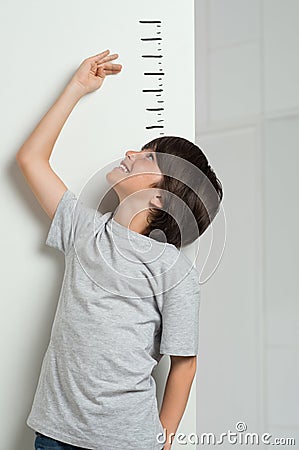 Boy measuring his height Stock Photo