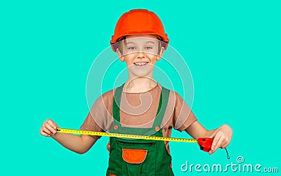 Boy with a measuring tape. Child dressed as a workman builder. Little boy wearing helmet. Little builder in hardhats Stock Photo