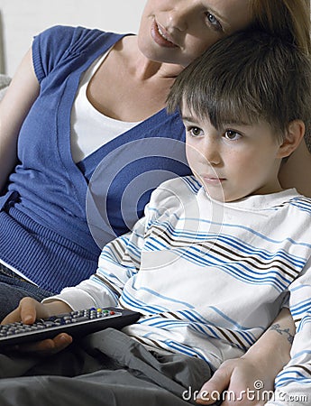 Boy And Mother Watching TV At Home Stock Photo