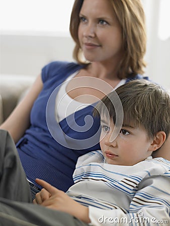 Boy And Mother Watching TV At Home Stock Photo