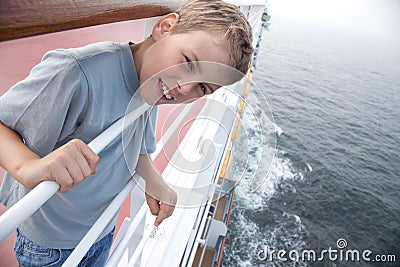 Boy near handrails on deck of ship Stock Photo