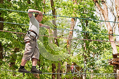 A boy overcomes obstacles, walking on a rope Stock Photo