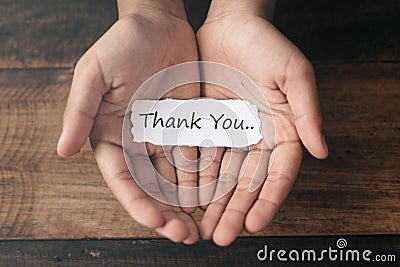 A boy with a paper note in his hands with the words THANK YOU Stock Photo