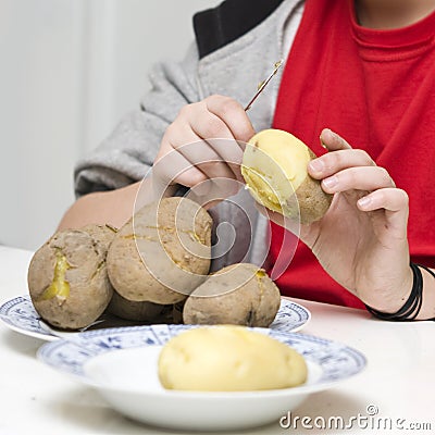 Boy peeling potatoes Stock Photo