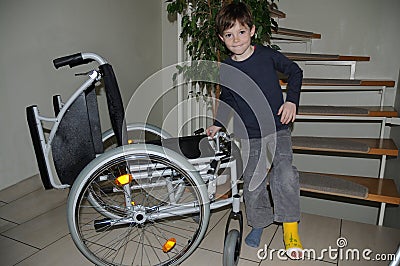 Boy with plaster leg limping to his wheelchair Stock Photo